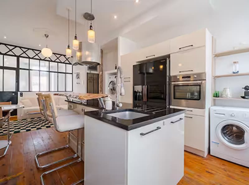 Cuisine équipée moderne avec îlot central, parquet bois et électroménager inox — exemple d'intérieur de particulier entretenu par niiickel à Toulouse-Ouest